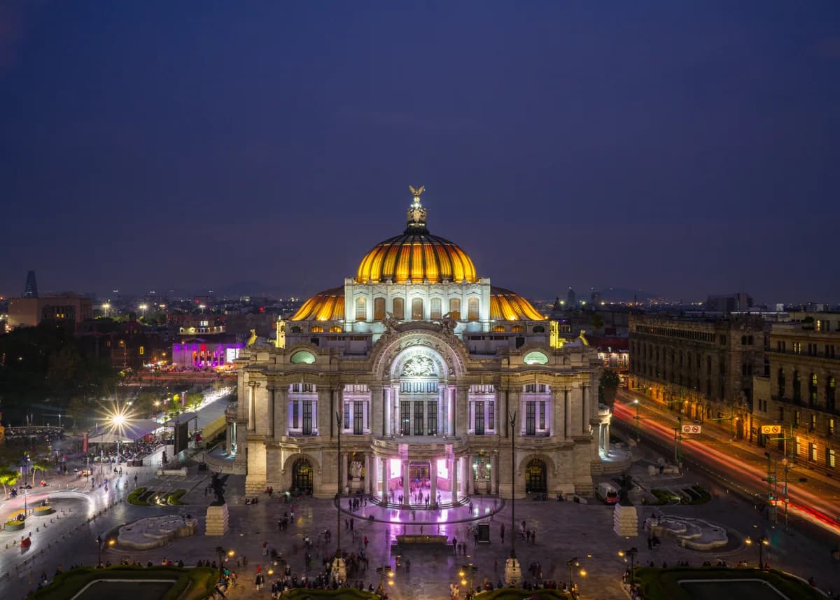 Golden dome and illuminated facade of the Palacio de Bellas Artes in Mexico City at night