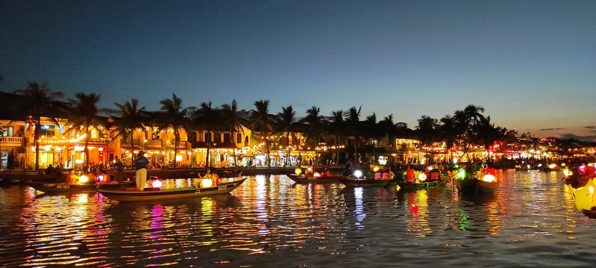 Lantern-lit boats and colorful reflections on the Thu Bon River in Hoi An, Vietnam, at dusk